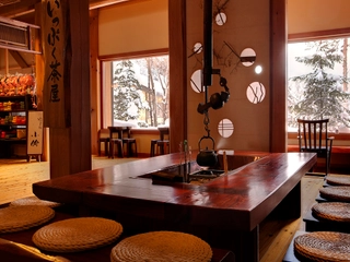 【ロビーの囲炉裏:冬】ロビーでは飛騨の銘木を使用した重鎮な柱と囲炉裏がお出迎え。チェックインのお手続きはこちらで。