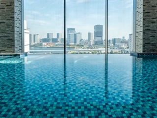 【最上階 プール】大きな窓からは、パノラマ写真のような都会の街並みを一望できます(有料/大人のみ)