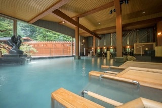 【大浴場】「鳳山の湯」の中にある寝湯。大きな窓から自然を眺めながらゆっくりと湯浴みをお愉しみ下さい。