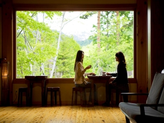 【ロビー:夏】大きな一枚ガラスからは、四季折々で表情を変える雄大な山並みを望めます。