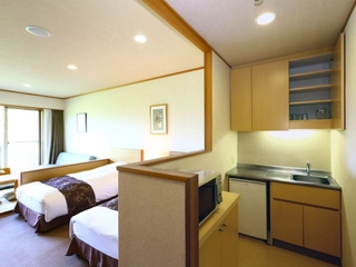 【広々ゆったり和洋室】高さのあるベッド2台を備えており、畳にはお布団を敷くことも。