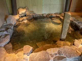 【大浴場/内湯】力強く美しい渓谷と雄大な豊平川-定山渓らしさをイメージした岩風呂