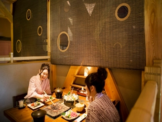 【食事処】テーブル中央の炭火を囲んんで、飛騨牛料理に舌鼓。