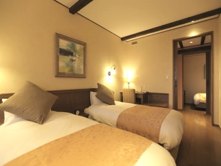 【ラビスタトリプル】リビングにベッド2台、奥の個室にベッド1台が設けられた一風変わった間取りの客室です。