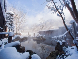 【大浴場露天風呂（冬）】雪化粧した山々を望みながらの湯浴みは格別。