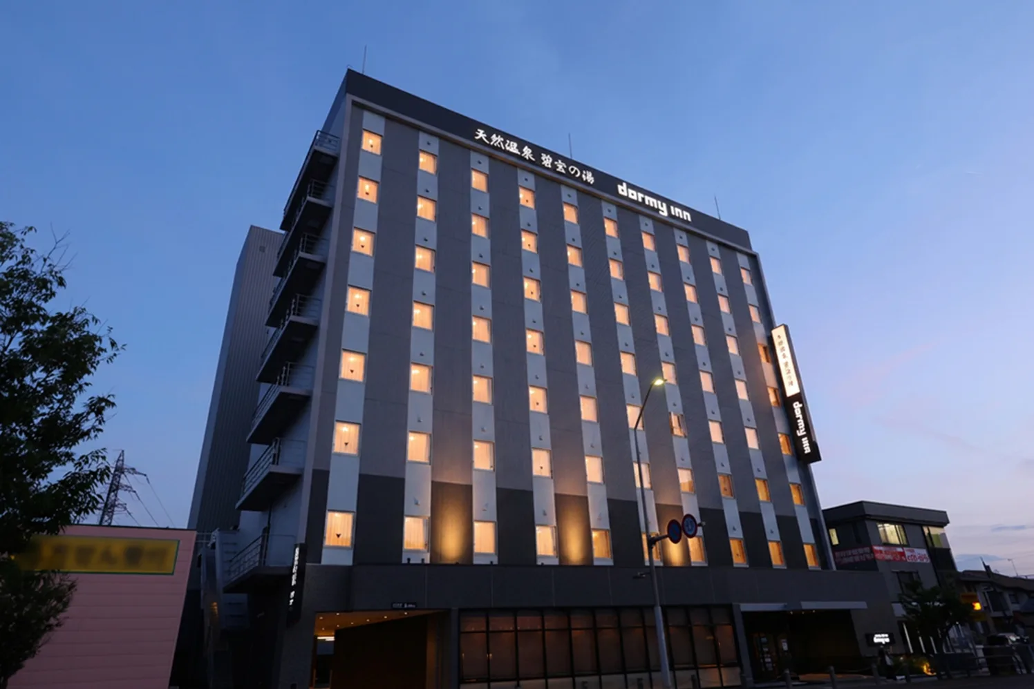 夕暮れに佇むドーミーイン小松の外観